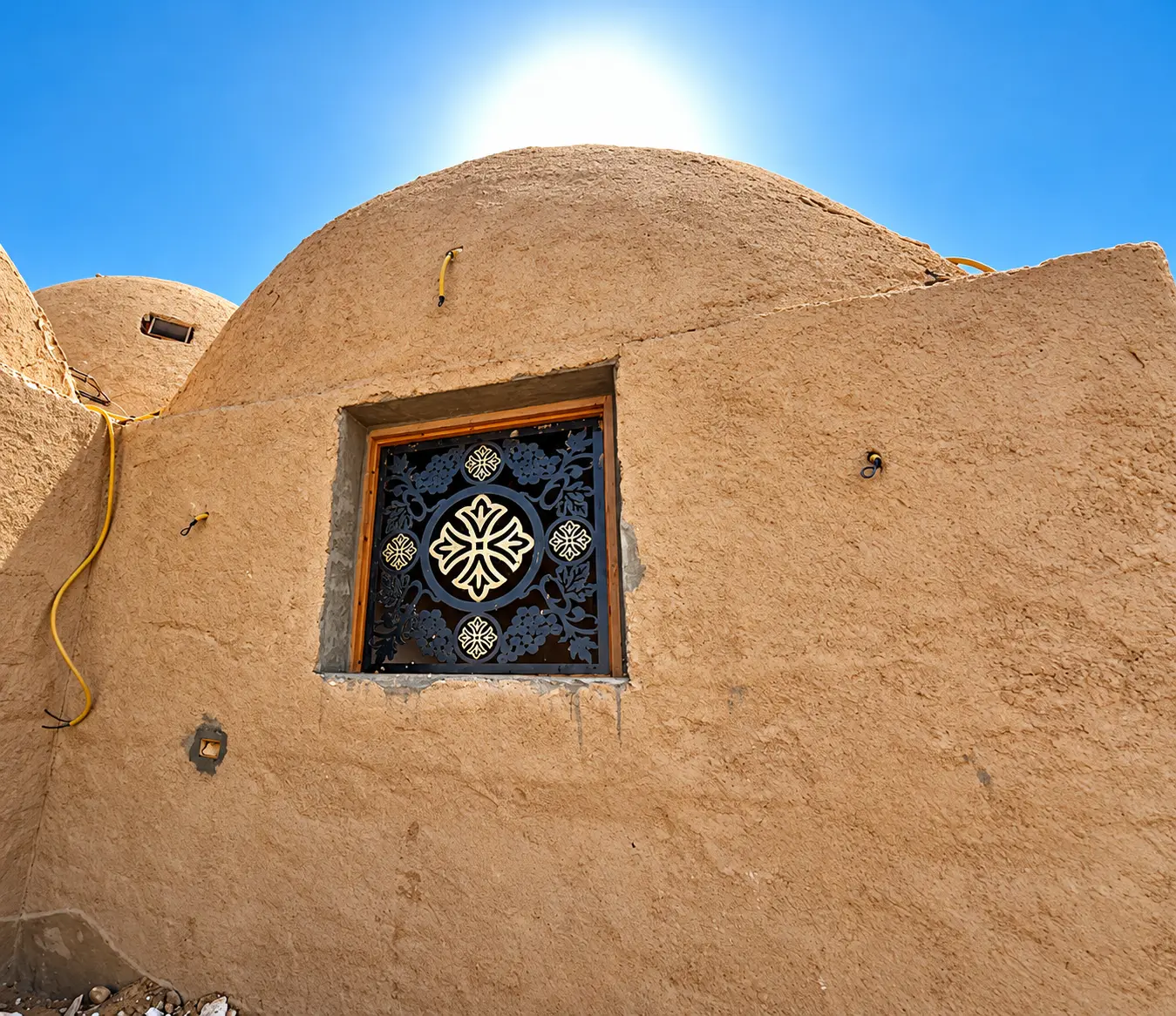 Sunlit adobe dome with an ornate window at the Monastery of Saint Pachomius near Luxor