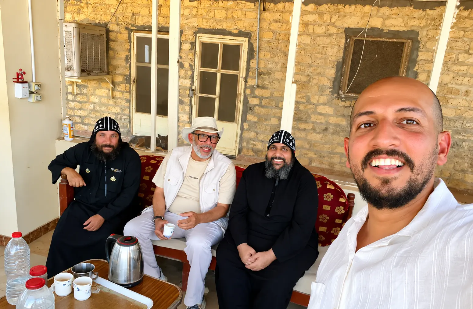 Muslim and Christian friends sharing tea on the monastery porch in Upper Egypt